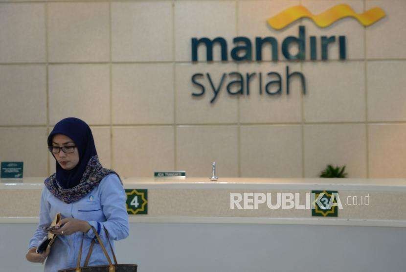 Pertumbuhan Dana Pihak Ketiga. Petugas melayani transaksi nasabah di kantor layanan Bank Syariah Mandiri, Jakarta, Senin (13/8).