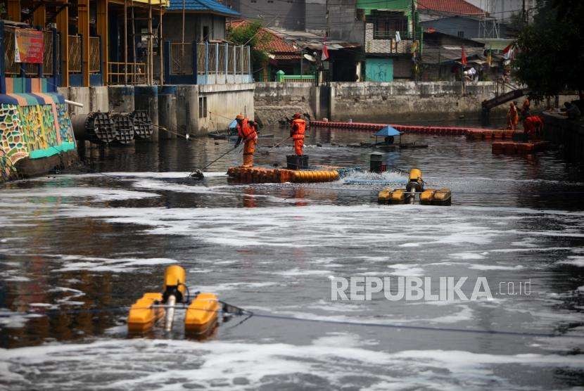 Petugas Penanganan Prasarana dan Sarana Umum (PPSU) membersihkan sampah di tengah pengoperasian Nano Bubble dan Aerator di Kali Sentiong atau Kali Item, Jakarta, Kamis (2/8).