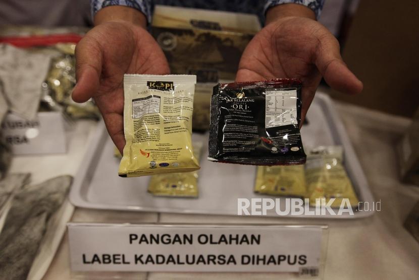 Petugas melihat barang bukti temuan sejumlah makanan dan kopi dalam kemasan yang dinilai diedarkan secara ilegal di Jakarta, Senin (20/5).