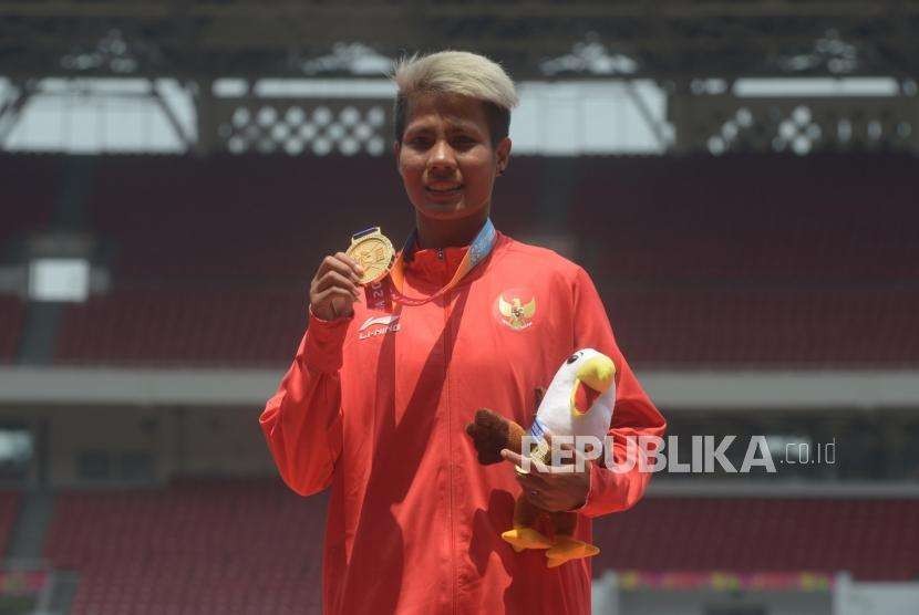 Atlet Indonesia  Rika Oktavia  berfoto usai menerima medali emas para-atletik putri T20 nomor lompat jauh Asian Para Games di Stadion Utama Gelora Bungkarno, Jakarta, Senin (8/10).