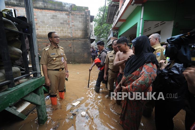 Gubernur DKI Jakarta Anies Baswedan(kiri) melakukan peninjauan ke wilayah yang terkena banjir di Gang Arus, Cawang, Jakarta Timur, Selasa (6/2).