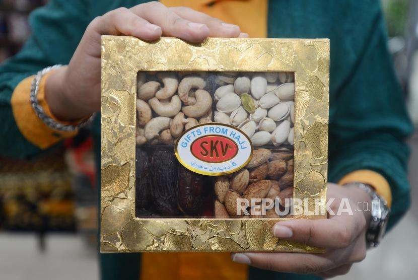 Petugas memperlihatkan salah satu produk oleh-oleh haji yang dijual di Bursa Sajadah, Jakarta, Selasa (7/8).