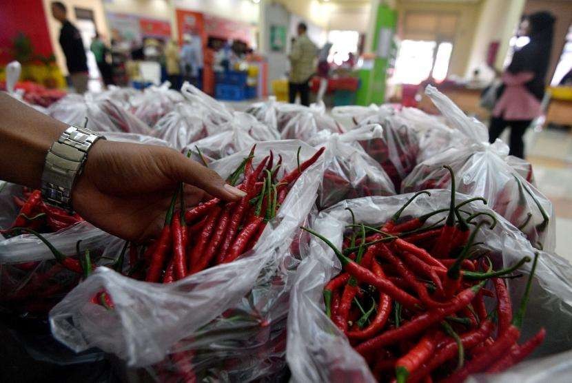 Pedagang menunjukkan cabai merah yang dijual di Toko Tani Indonesia Centre, Pasar Minggu, Jakarta Selatan, Jumat (25/5).