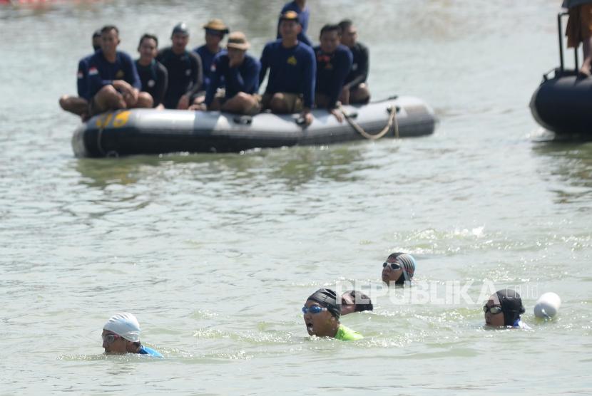 Wagub DKI Jakarta Sandiaga Uno berenang saat kompetisi adu cepat dengan Menteri Kelautan dan Perikanan Susi Pudjiastuti dalam festival Danau Sunter, Jakarta, Ahad (25/2).