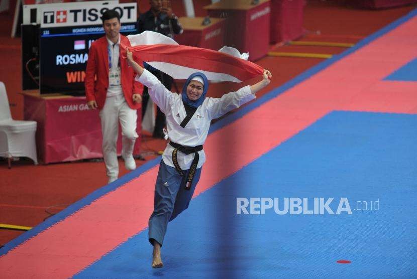 Atlet taekwondo putri Indonesia Defia Rosmaniar melakukan selebrasi seusai meraih medali emas dalam cabang taekwondo nomor poomsae Asian Games 2018 di Jakarta Convention Center, Senayan, Jakarta, Ahad (19/8).