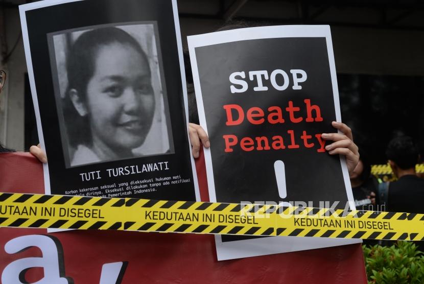 Massa unjuk rasa membawa foto dan poster   TKI Indonesia Tuti Tursilawati saat  unjuk rasa di depan Kedutaan Arab Saudi, di Jakarta, Jumat (11/2).