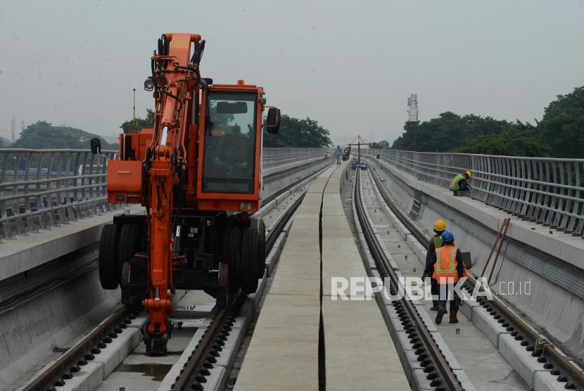 Pekerja menyelesaikan pembangunan stasiun LRT Taman Mini di Jakarta, Senin, (14/1).