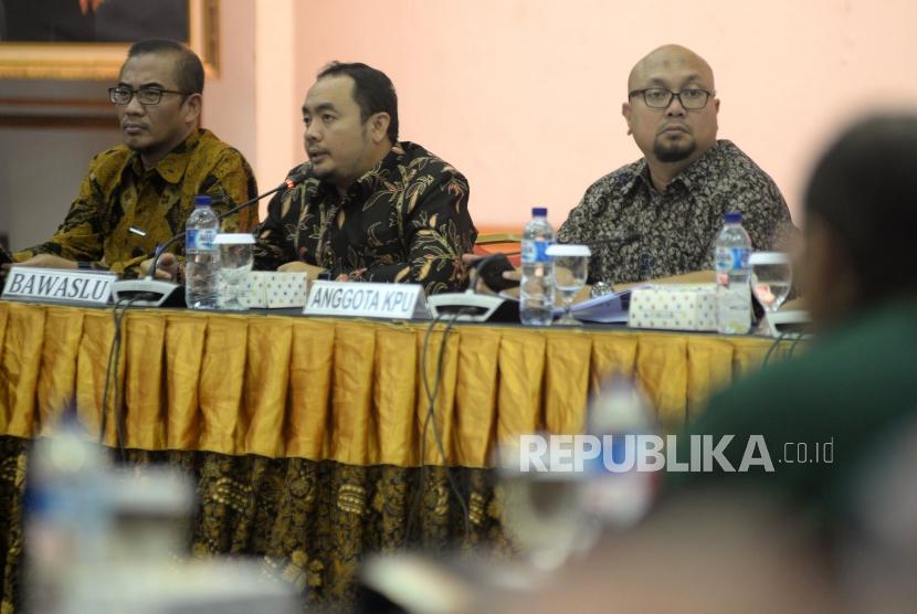 Anggota Bawaslu Mochammad Afifuddin (tengah) menyampaikan pandangannya disaksikan Anggota KPU Hasyim Azhari (kiri) dan Ilham Saputra (kanan) dalam rapat koordinasi persiapan tahapan pendaftaran pemilihan umum 2018 di Jakarta, Kamis (4/1).