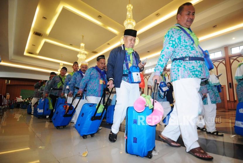 Sejumlah calon jamaah haji mengantre untuk melakukan pemeriksaan pasport sebelum berangkat ke Bandara Soekarno Hatta di Asrama Haji Pondok Gede, Jakarta, Rabu (18/7).