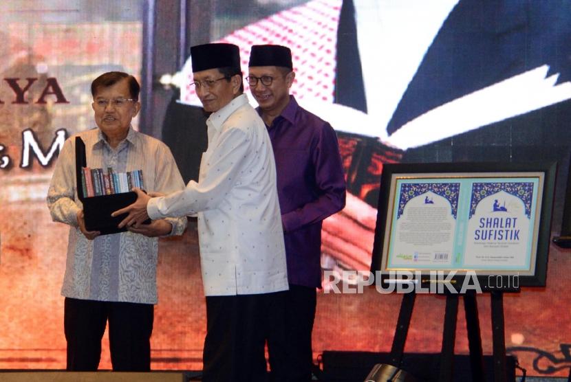 Imam Besar Masjid Istiqlal Nasaruddin Umar memberikan buku karanganya kepada Wakil Presiden Jusuf Kalla pada acara tasyakuran 60 tahun dan peluncuran buku di Jakarta, Ahad (23/6).