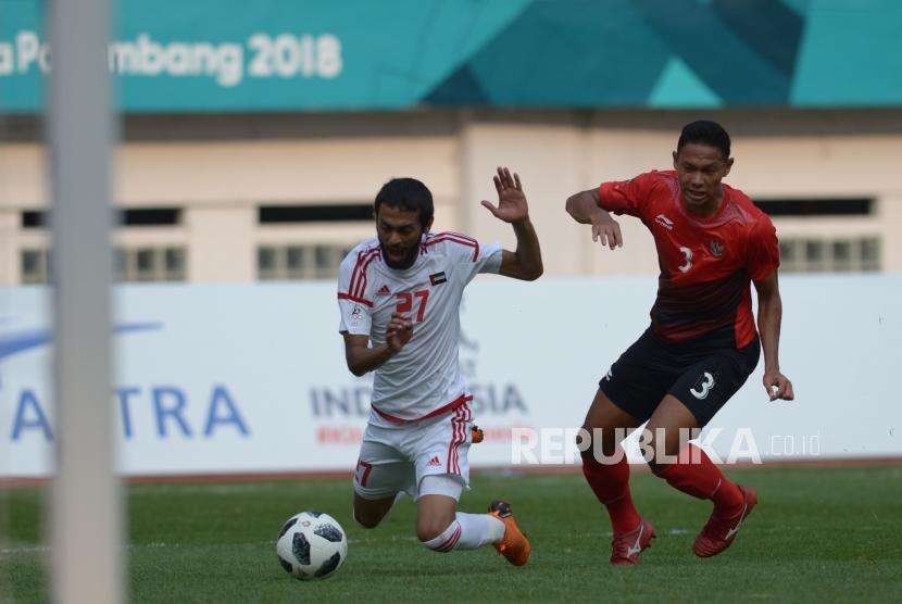Pesepakbola Indonesia Ricky Fajrin Saputra berebut bola dengan pesepakbola Uni Emirate Arab Zayed Alamaeri dalam pertandingan cabang sepakbola Asian Games 2018 di Stadion Wibawa Mukti, Cikarang, Jawa Barat, Jumat (24/8).