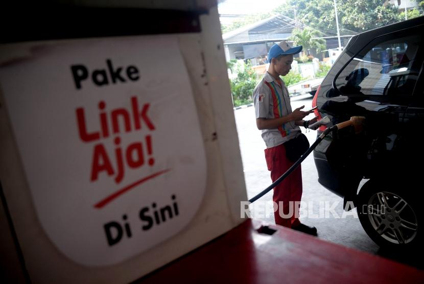 Petugas membantu konsumen melakukan transaksi pembayaran menggunakan layanan keuangan berbasis elektronik LinkAja di SPBU Kuningan, Jakarta, Senin (1/7).