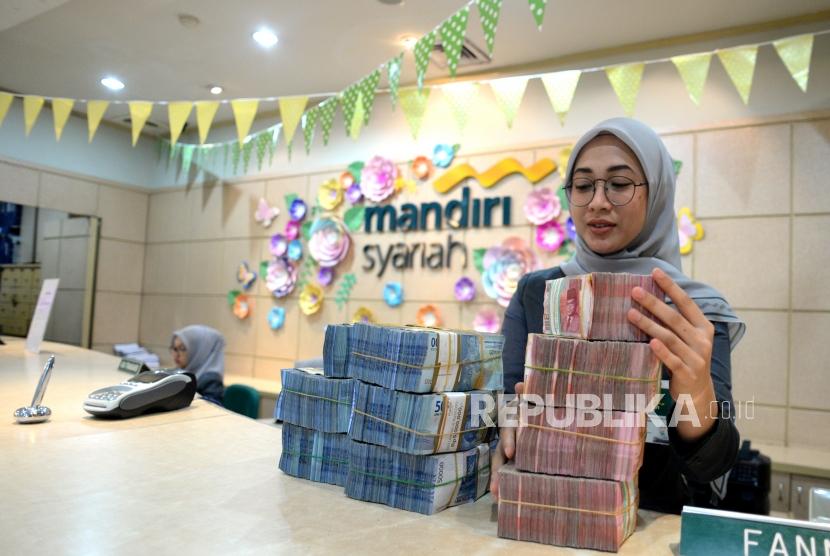 Peningkatan DPK. Petugas melayani nasabah di Bank Syariah Mandiri cabang Thamrin, Jakarta, Kamis (9/11).