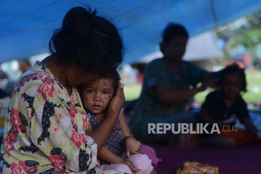 Ulan (1) salah satu anak yang selamat dari bencana gempa bumi saat berada di tenda pengungsian di Lapangan Kantor Walikota Palu, Sulawesi Tengah, Senin (1/10).