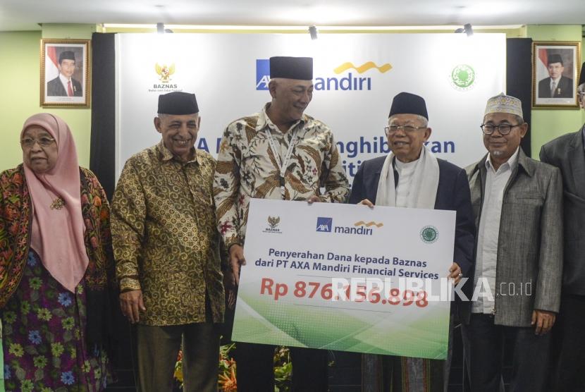 Director of Sales AXA Mandiri Henky Oktavianus (ketiga kiri) bersama Ketua Umum MUI KH Ma'ruf Amin (kedua kanan) dan Komisioner Baznas Ahmad Satori (kanan) saat penyerahan dana surplus underwriting secara simbolis di Gedung MUI, Jakarta, Selasa (24/9).