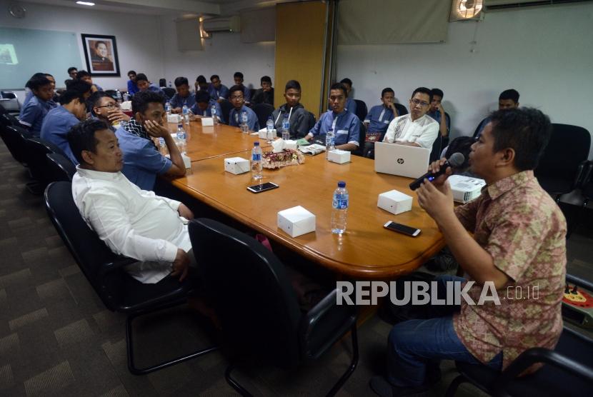 Wakil Redaktur Pelaksana Harian Republika Heri Ruslan (kanan) memberikan penjelasan kepada siswa Pesantren At Taqwa yang didampingi Guru Jurnalistik Nuim Hidayat (kiri) saat berkunjung ke Kantor Republika, Jakarta, Jumat (25/1).