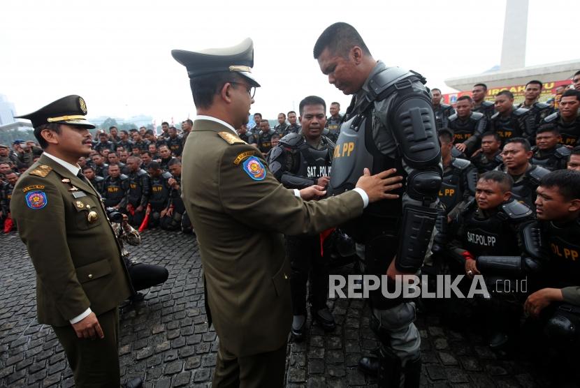 Gubernur DKI Jakarta Anies Baswedan meninjau personil Satpol PP saat menghadiri Apel besar dalam rangka memperingati HUT Satpol PP ke-68 di Lapangan Monas, Jakarta, Kamis (26/4).