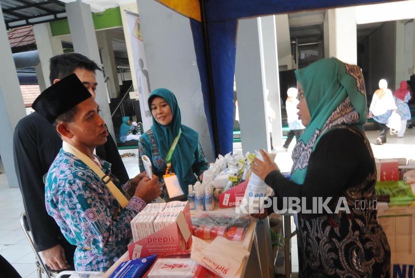 Keberangkatan Calon Haji Jawa Barat. Sejumlah jamaah membeli perlengkapan kesehatan di Asrama Haji Embarkasi di Bekasi, Jawa Barat, Senin (8/7).