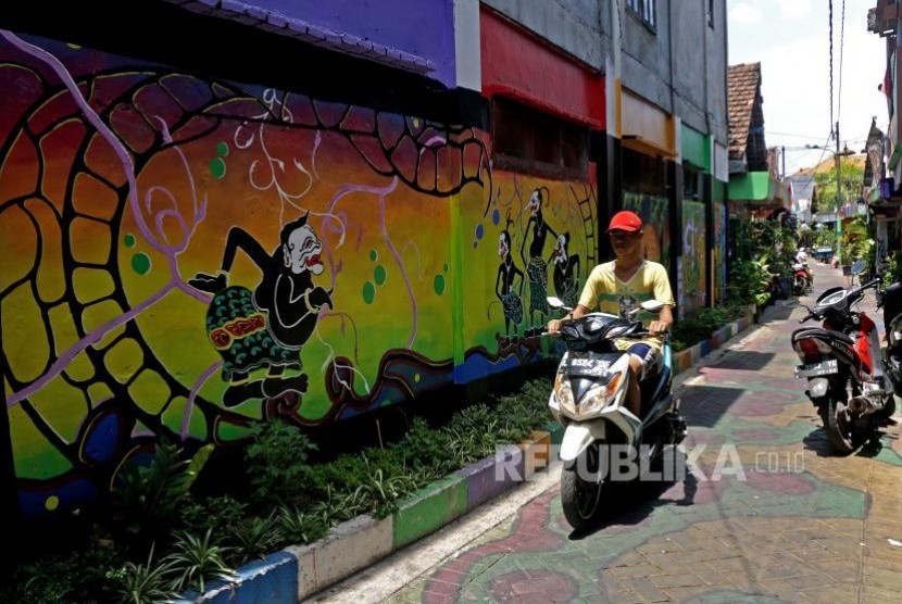 Warga dengan menggunakan sepeda motor melintas di sekitar kawasan eks lokalisasi Dolly, Surabaya, Jawa Timur, Senin (6/11).