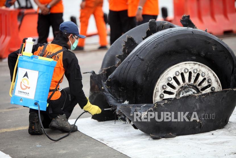 Petugas menyemprotkan disinfektan ke puing-puing pesawat Lion Air JT-610 di Tanjung Priok, Jakarta, Senin (5/11).