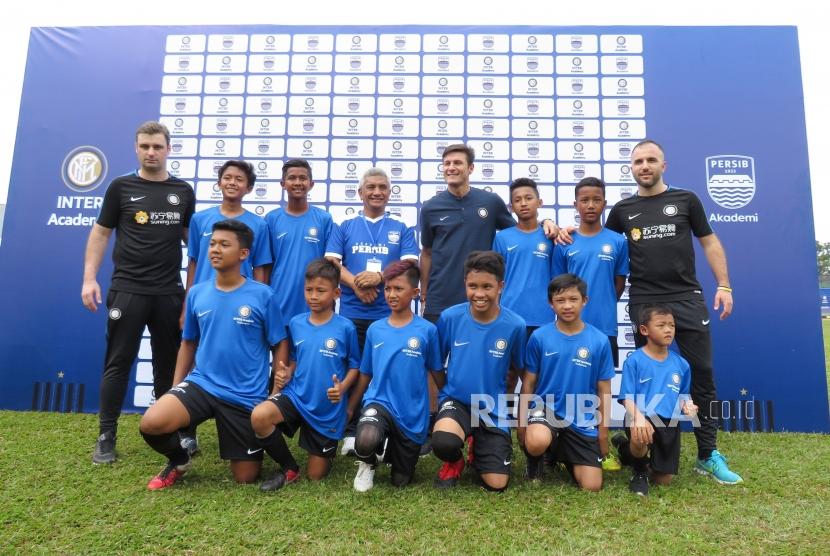 Legenda Inter Milan Javier Zanetti bersama para pelatih berfoto bersama dengan anak-anak didik pada peluncuran Akademi Persib yang merupakan partnership program bersama Inter Academy di Stadion Siliwangi, Kota Bandung, Selasa (13/2).