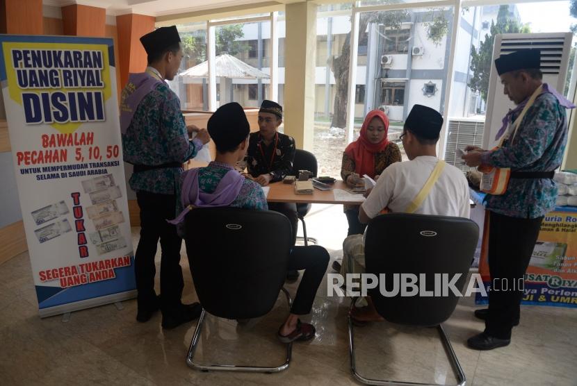 Petugas melayani penukaran mata uang Riyal untuk calon jamaah haji di Asrama Haji Pondok Gede, Jakarta, Jumat (19/7).