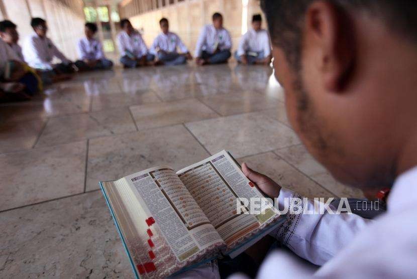 Seorang pelajar membaca Alquran seusai salat Jumat di Masjid Istiqlal, Jakarta, Jumat (31/8).