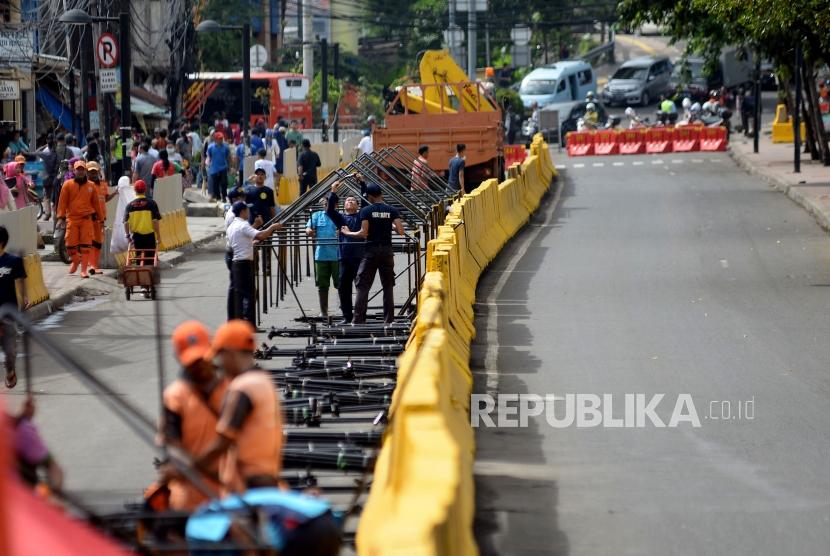 Petugas PPSU mendirikan tenda yang akan digunakan pedagang kaki lima (PKL) untuk berjualan ketika dilakukanya penutupan Jalan Jatibaru di Kawasan Tanah Abang, Jakarta, Jumat (22/12).