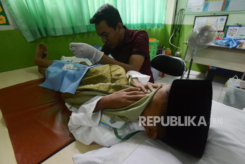 Khitan Pertama Disyariatkan pada Nabi Ibrahim. Anak-anak menutup matanya saat mengikuti kegiatan sunat massal.