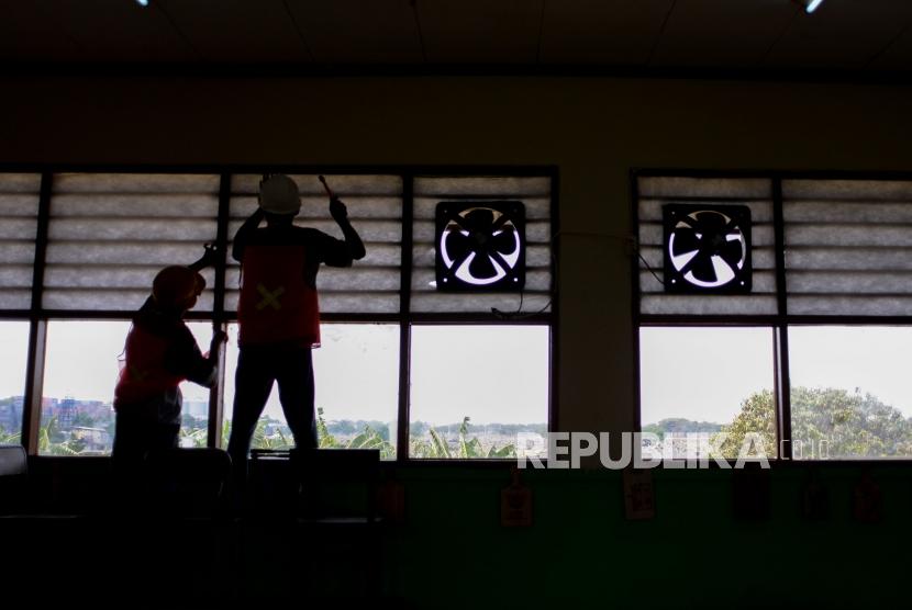 Siswa SMK Negeri 4 Jakarta Utara memasang penyaring udara di ruangan kelas SD Negeri 07 Pagi, Cilincing, Jakarta Utara, Kamis (18/9/2019).