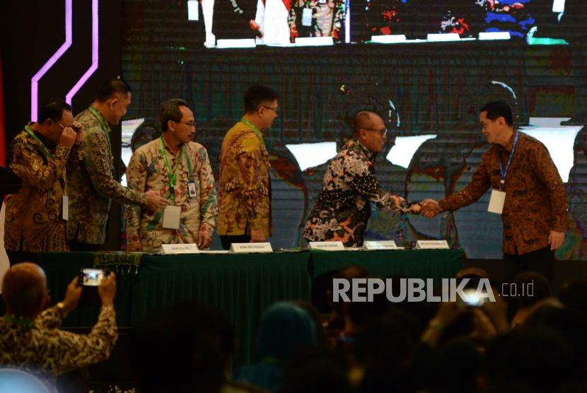 Direktur Utama BPJS Ketenagakerjaan Agus Susanto (dua kanan) bersalaman dengan Direktur Eksekutif KNKS Ventje Rahardjo  menandatangani nota kesepahaman bersama disela acara peluncuran masterplan ekonomi syariah Indonesia 2019-2024 di Jakarta, Selasa (14/5).