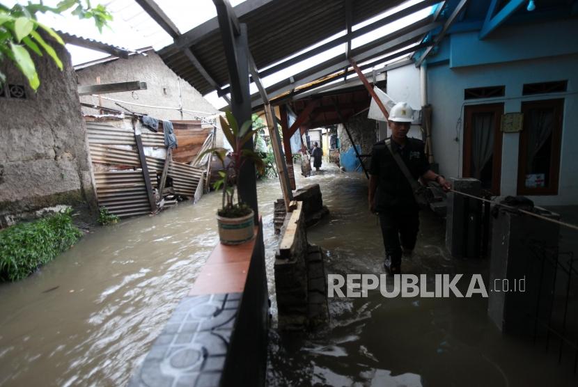 Petugas melintas disamping genangan air akibat tanggul jebol Kali Pulo, Jatipadang, Jakarta. (Ilustrasi)