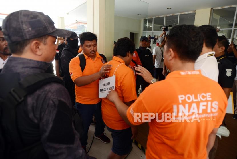 Sejumlah petugas kepolisian bersama tersangka saat reka ulang adegan kasus peluru nyasar di Lapangan Tembak, Senayan, Jakarta Selatan, Jumat (19/10).
