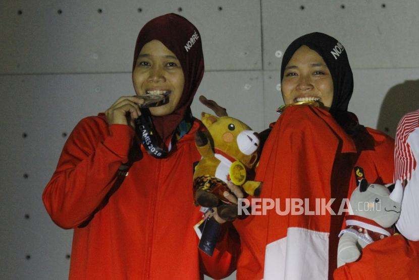 Emas Dari Panjat Dinding. Pemanjat Dinding Indonesia Aries Susanti Rahayu (kanan) dan Puji Lestari saat upacara pengalungan medali pada cabang panjat dinding nomor kecepatan putri Asian Games 2018 di Komplek Olahraga Jakabaring, Kamis (23/8) malam.