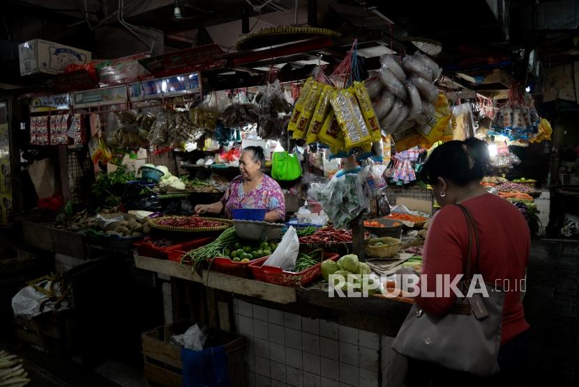 Komoditas Pangan Sumbang Inflasi Desember. Pedagang melayani pembeli di Pasar Tebet Barat, Jakarta, Rabu (3/1).