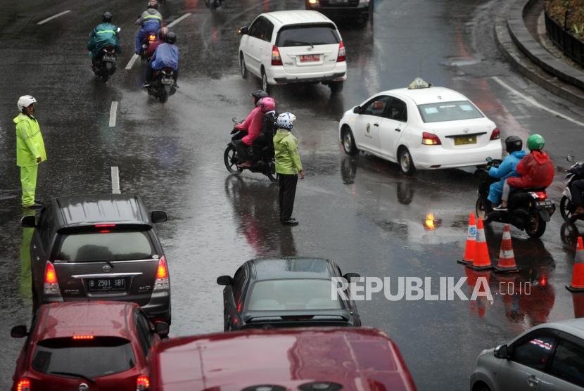 Petugas kepolisian mengatur lalu lintas saat uji coba Sistem Ganjil Genap di Kawasan Bundaran Hotel Indonesia, Jakarta, Senin (23/4).