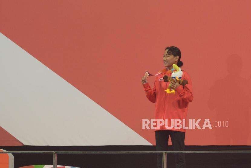 Atlet para renang Indonesia Indriani Syuci berfoto usai menerima medali perunggu pada babak final putri 200m gaya bebas S14 para renang Asian Para Games 2018 di Aquatic Center, Gelora Bung Karno, Jakarta,  Ahad (7/10).