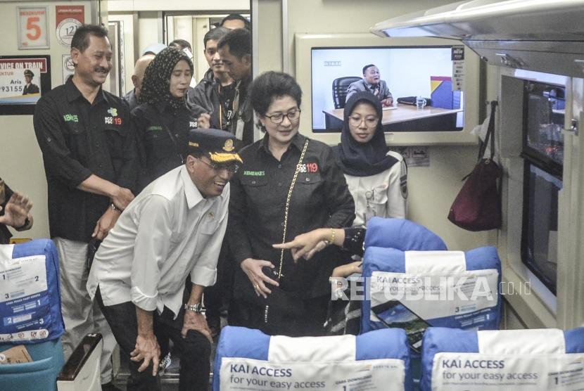 Menteri Perhubungan Budi Karya Sumadi (tengah) bersama Menteri Kesehatan Nila F Moeloek (kedua kanan) saat berbincang dengan penumpang kereta di Stasiun Gambir, Jakarta Pusat, Minggu (26/5).