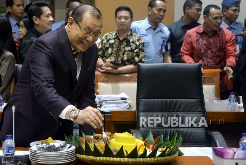 Ketua Komisi III DPR Kahar Muzakir mengambil potongan tumpeng saat pelantikan di Kompleks Parlemen, Senayan, Jakarta, Rabu (24/1).