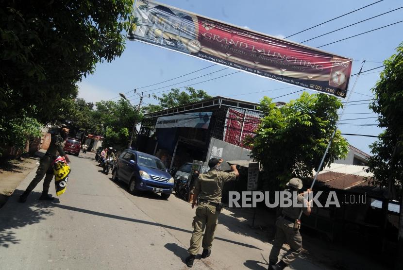 Petugas Satpol PP mencabut spanduk yang terpasang di kawasan Beji, Depok, Jawa Barat, Rabu (6/12).