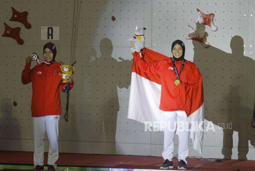 Emas Dari Panjat Dinding. Pemanjat Dinding Indonesia Aries Susanti Rahayu (kanan) dan Puji Lestari saat upacara pengalungan medali pada cabang panjat dinding nomor kecepatan putri Asian Games 2018 di Komplek Olahraga Jakabaring, Kamis (23/8) malam. 