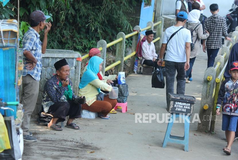 Sejumlah pengemis berharap sedekah di jalan masuk TPU Cikutra, Kota Bandung, Rabu (16/5).