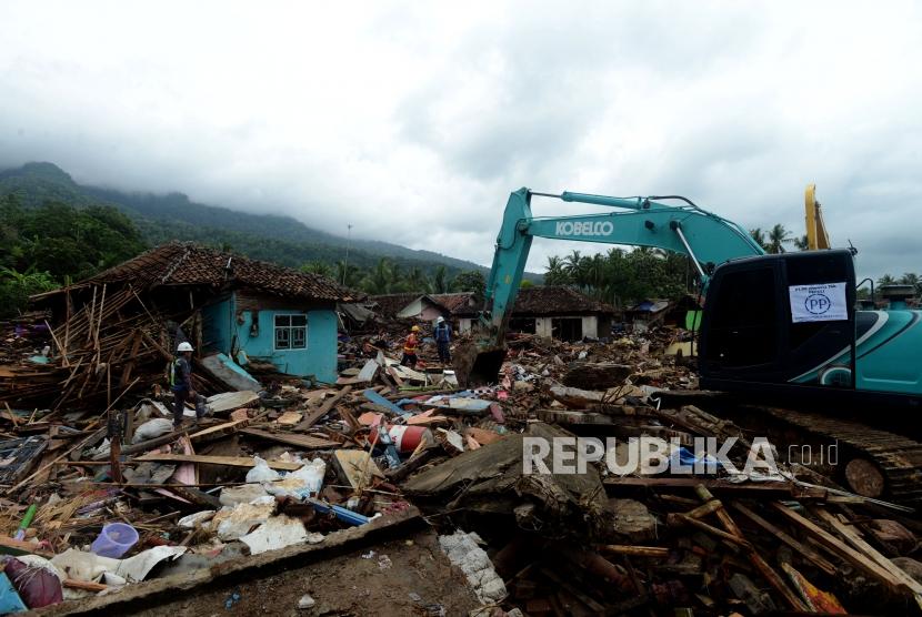 Sejumlah alat berat melakukan evakuasi bangunan yang terdampak tsunami di Desa Way Muli, Kalianda, Lampung Selatan, Senin (24/12).