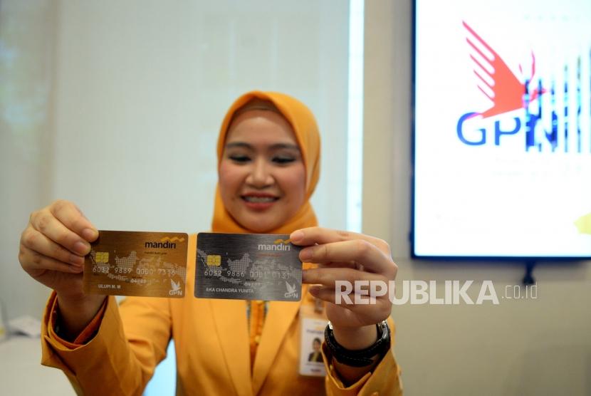Mandiri Debit Logo GPN. Petugas menunjukan kartu Mandiri Debit berlogo Gerbang Pembayaran Nasional (GPN) di kantor layanan Bank Mandiri, Jakarta, Senin (9/4).