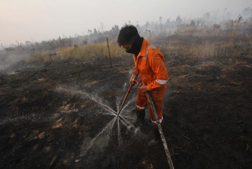 Satgas Kebakaran hutan dan lahan (Karhutla) dari Dinas Kehutanan Kalsel menggunakan alat suntik gambut (Sunbut) saat berupaya memadamkan kebakaran lahan gambut di kawasan Syamsudin Noor, Banjarbaru, Kalimantan Selatan, Sabtu (14/9/2019).