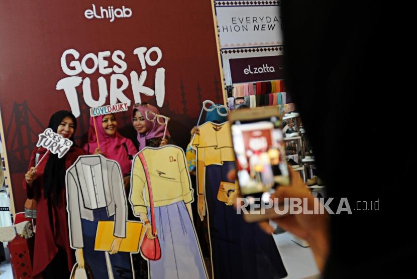 Calon pembeli berfoto di depan stan Elhijab pada acara Muslim Fashion Festival 2018 di Jakarta Convention Center, Jakarta, Kamis (19/4).