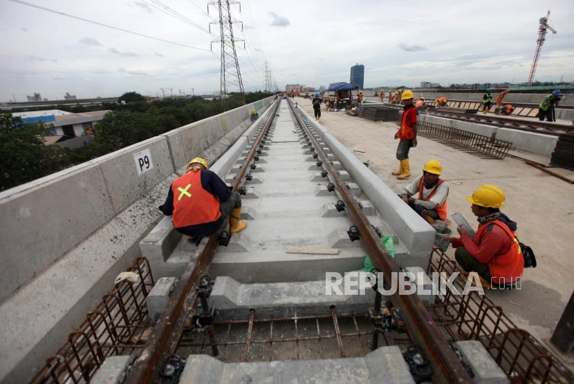 Sejumlah pekerja menyelesaikan proyek pembangunan Light Rail Transit (LRT) Koridor 1 di Depo LRT, Kelapa Gading, Jakarta, Kamis (25/1).