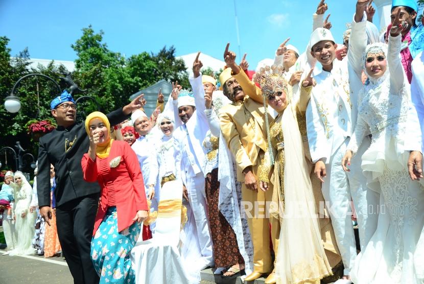 Wali Kota Bandung Ridwan Kamil beserta istri berfoto bersama dengan puluhan pasangan pengantin pada acara Nikah Masal di Pendopo, Kota Bandung, Rabu (22/11).