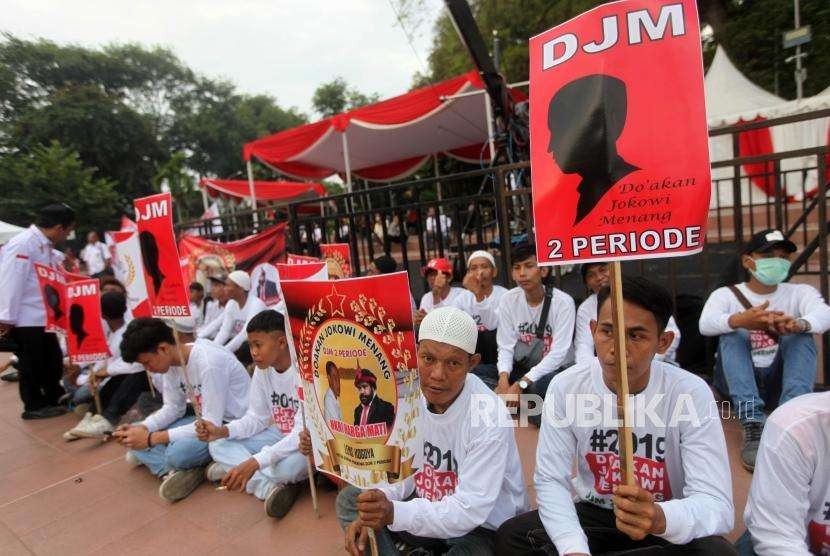 Relawan Jokowi-Ma'ruf Amin berkumpul untuk menunggu kedatangan capres petahana Joko Widodo bersama cawapres Ma'ruf Amin di Tugu Proklamasi, Jakarta, Jumat (21/9).