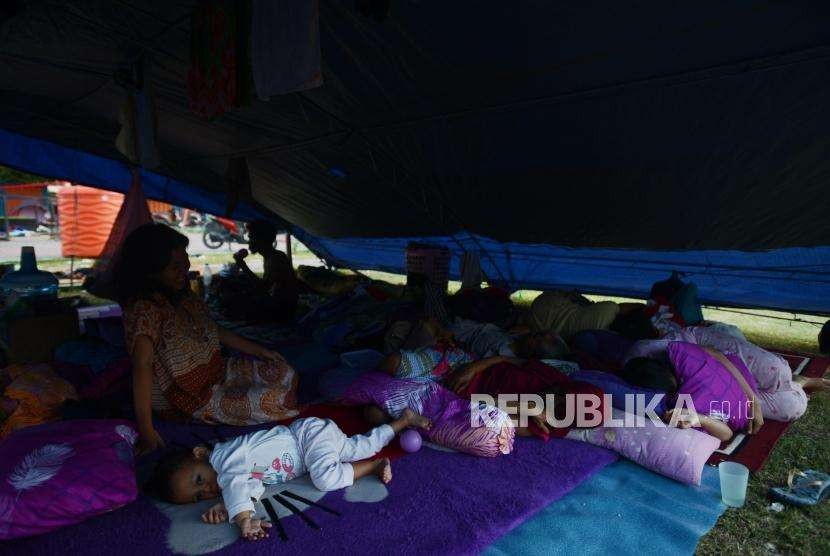 Sejumlah warga beristirahat di tenda pengungsian di Lapangan Vatulemo, Palu, Sulawesi Tengah, Senin (1/10).